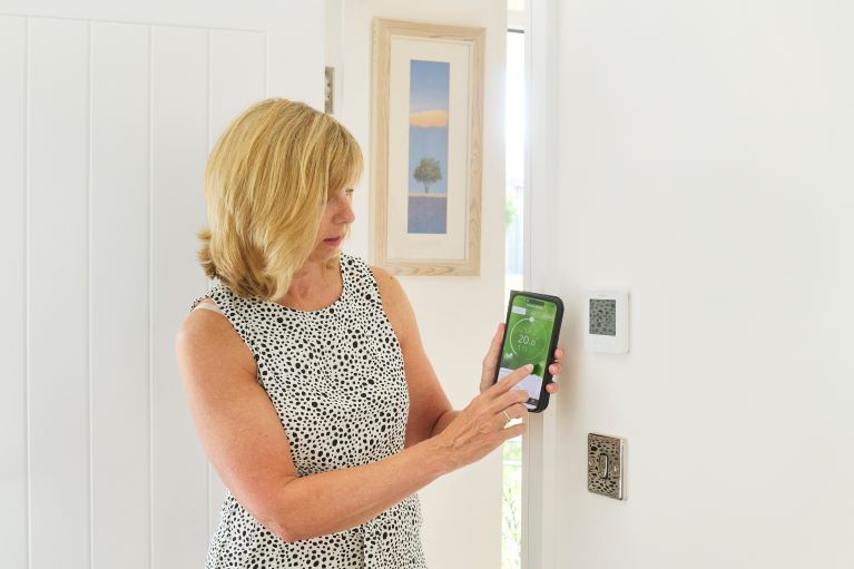 A person controlling heating on a phone