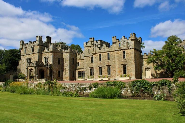 Castle with a large lawn, blue sky