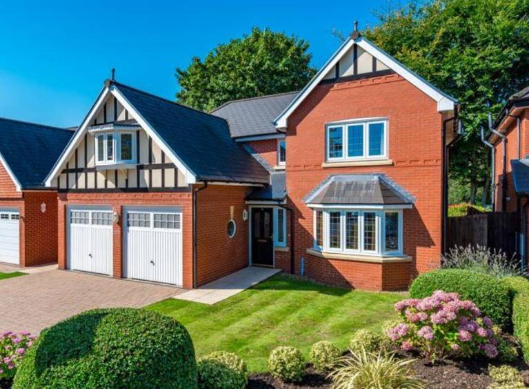 A red detached home with a drive