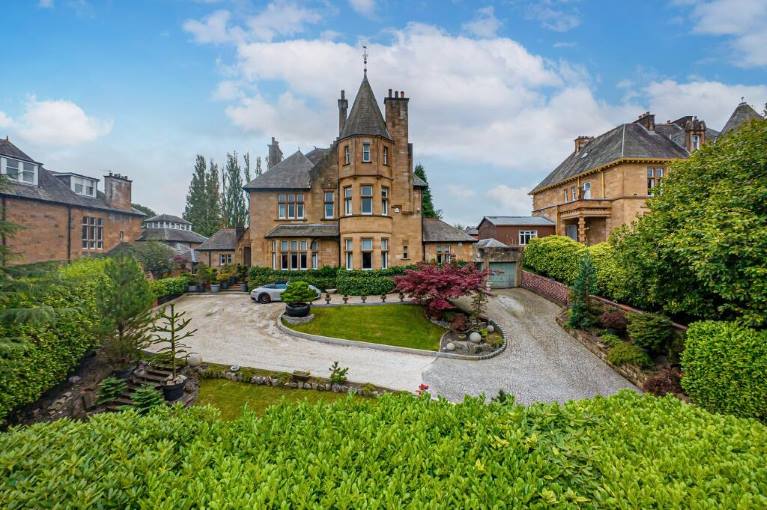 A villa with a driveway, blue sky