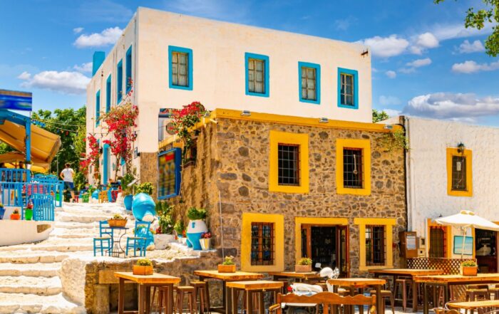 A stone home in Greece, on the Aegean Islands with chairs outside for outdoor dining